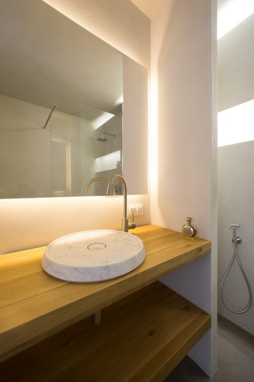 Badkamer met mooi balans van betonstuc en hout