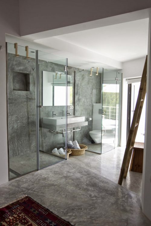 Betonstuc badkamer met twee glazen cabines