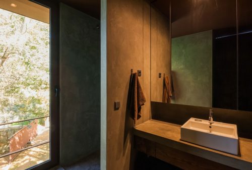 Betonstuc en walnoot hout in badkamer