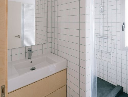 Deze badkamer met een zwarte rubberen vloer