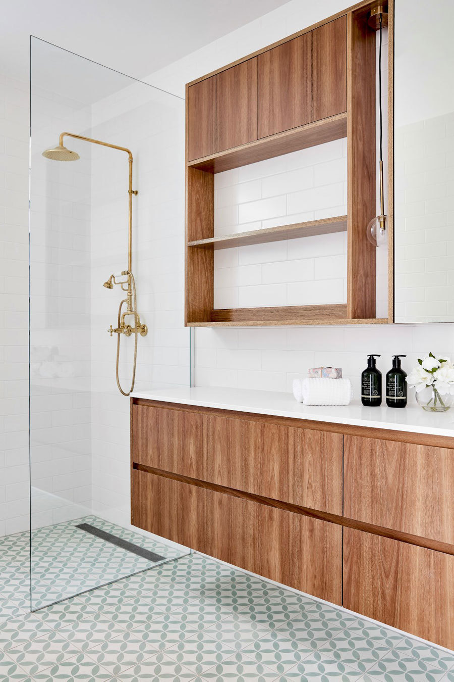 Deze kleine badkamer is super leuk ingericht met patroontegels en houten meubel