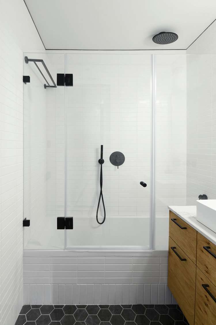 In deze kleine stoere badkamer vind je een mooie bad-douche-combinatie!
