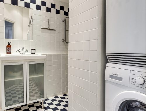 Kleine l-vormige badkamer met wasmachine en droger