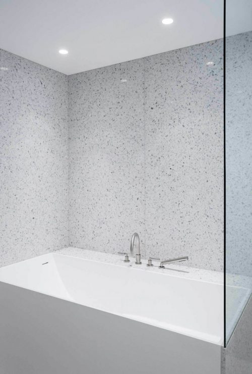 Minimalistische badkamer met gespikkelde witte tegels