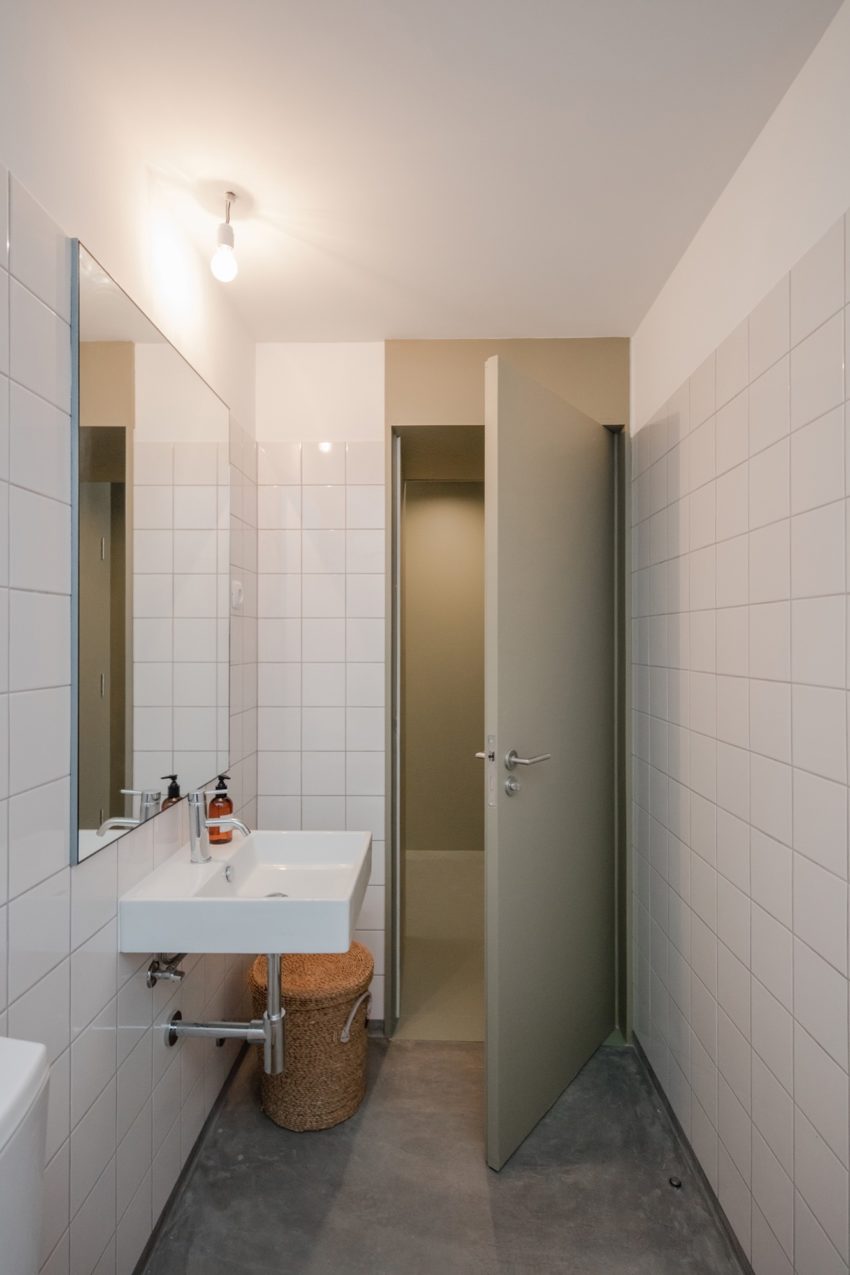 Minimalistische kleine badkamer met betonlook vloer en witte wandtegels