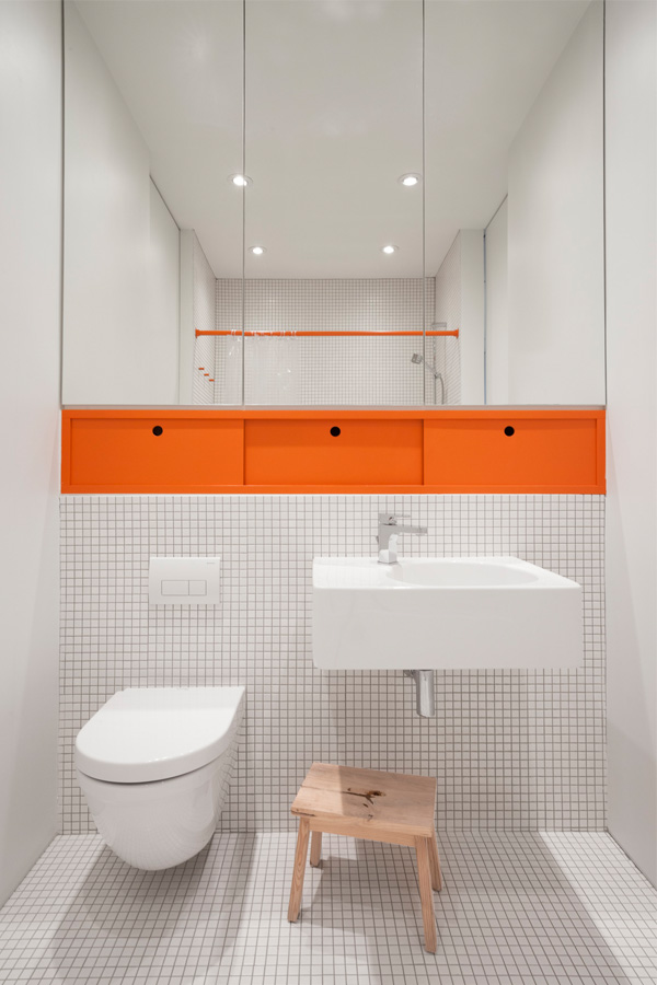 Minimalistische witte badkamer met oranje accenten
