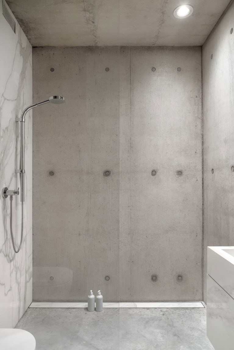 Moderne badkamer met beton, hout en marmer