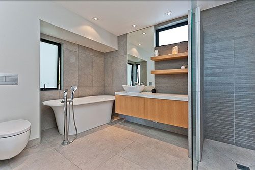 Moderne badkamer met vrijstaand bad tegen de muur