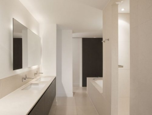 Strakke witte badkamer met langwerpige badmeubel