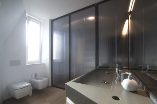 Verborgen ligbad in een stoere badkamer